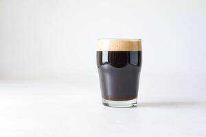 A Glass of Dark Beer with a Creamy Foam Head photo
