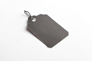 Blank black tag with string isolated on white background photo
