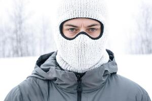 Man in a white knit balaclava and a gray jacket photo