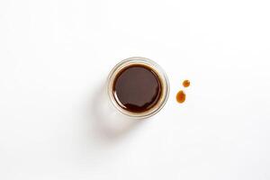Small Glass Bowl with Dark Liquid and Splashes photo