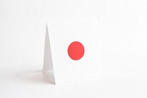 Folded Piece of Paper with a Red Circle on White Background photo