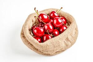 Close-up of Cherries in a Burlap Sack on a White Background photo