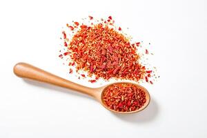 Dried Red Chili Flakes in Wooden Spoon on White Background photo