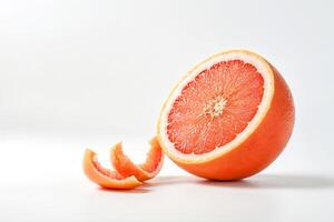Close-up of a grapefruit cut in half, with peelings on white background photo