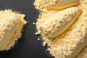 Close-up of Corn Kernels Covered in Butter and Crumbled on a Black Surface photo