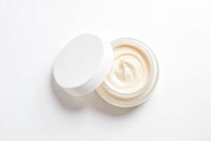 Close up of a jar of cream with a lid open on a white background photo