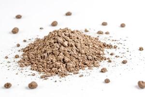 Pile of dirt with small clumps on white background photo
