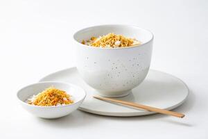 Bowl of Rice with Crispy Topping and Chopsticks on White Background photo