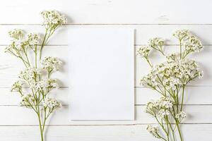Blank White Card with White Flowers on a White Wooden Background photo