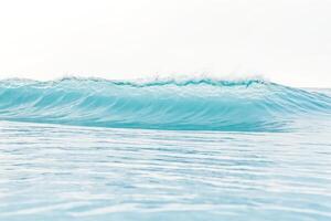 Turquoise Ocean Wave Breaking in Calm Waters photo