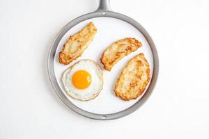 Fried egg and hash browns in a frying pan photo
