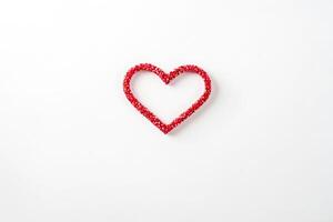 Red heart made of small red beads on white background photo