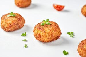Close-up of Crispy Fried Arancini with Parsley Garnish photo