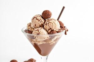 Close up of a glass of chocolate ice cream with chocolate sauce and chocolate truffles photo