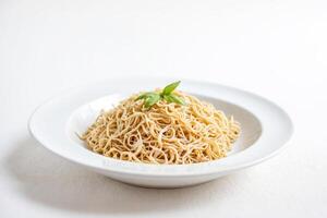 Close-up of a Plate of Cooked Noodles with Basil Garnish photo