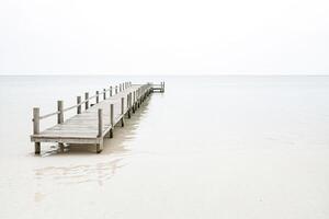Wooden pier extending into a calm sea photo