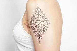 Closeup of a Woman's Arm with a Black Ink Mandala Tattoo photo