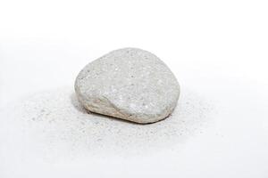 Single white rock on a white surface with tiny white pebbles photo