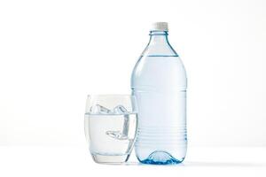 Glass of water with ice cubes and a bottle of water photo