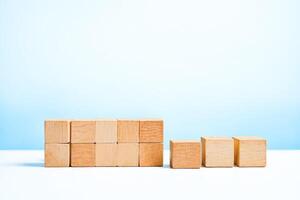 Wooden Blocks Arranged in a Row on a White Surface with a Blue Background photo