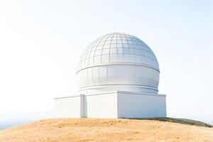 White dome observatory on a hilltop photo