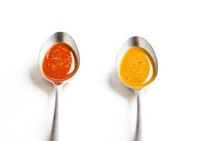 Red and Yellow Sauces in Spoons photo