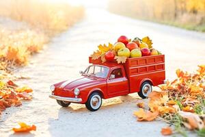 Red Toy Truck Full of Apples on a Fall Road photo