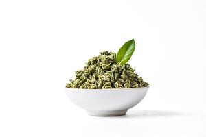 Green Tea Leaves in a Bowl with a Single Green Leaf photo