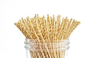Yellow and white striped drinking straws in a glass jar photo