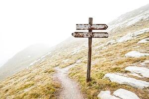Rusty Signpost on a Mountain Path photo