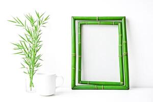 Bamboo Frame with a Cup of Tea and a Plant on a White Background photo