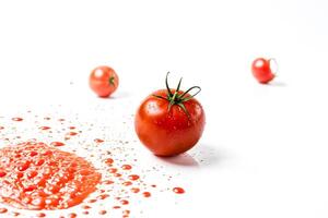 Ripe Tomatoes Splashed With Juice on a White Background photo