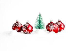 Red Christmas Baubles and a Tiny Christmas Tree in Snow photo