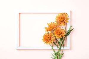 Orange Flowers and White Frame on Pink Background photo