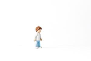 Toy figure of a boy standing on a white background photo