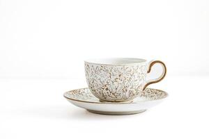 White Teacup with Golden Floral Design on White Background photo