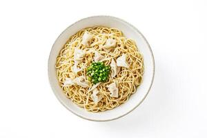 Bowl of noodles with dumplings and green onions photo