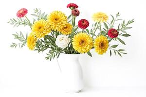 Yellow and Red Flowers in a White Vase photo