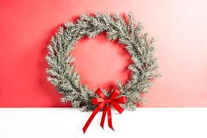 Minimalist Christmas Wreath with Red Bow on Pink and White Background photo