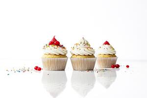 Three Delicious Cupcakes with Colorful Sprinkles and Red Cherries photo
