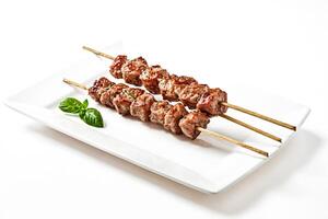 Grilled Pork Skewers with Basil on a White Plate photo