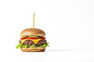 Close-up of a juicy cheeseburger with lettuce and tomato on a white background photo