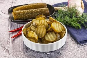 Sliced marinated cucumbers in the bowl photo
