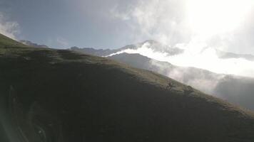 Aerial view single one tent on hilltop with green caucasus mountains panorama. Green camping tent on top of mountain with amazing sunrise on background. Time spending on fresh air. Traveling concept video
