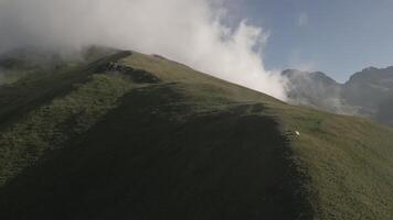 Aerial view single one tent on hilltop with green caucasus mountains panorama. Green camping tent on top of mountain with amazing sunrise on background. Time spending on fresh air. Traveling concept video