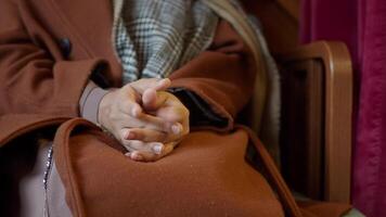 An individual sits calmly with folded hands in a warm and comfortable indoor environment video