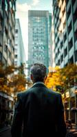 Rear view of a mature businessman standing in the city. photo