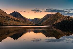 Sunset sky over Moke Lake reflect with mountain range and flock of duck at Queenstown, New Zealand photo
