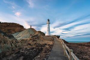 View of Castlepoint Lighthouse with beam on Wairarapa coast in the evening at New Zealand photo
