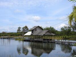Wooden house on small beautiful lake photo